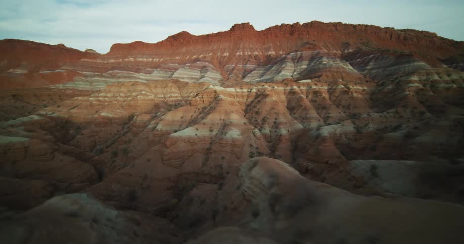 A van drives along a narrow dirt road along the top of a canyon