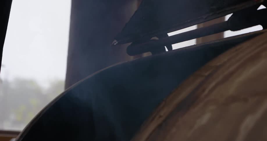A cook monitors a smoker being used indoors