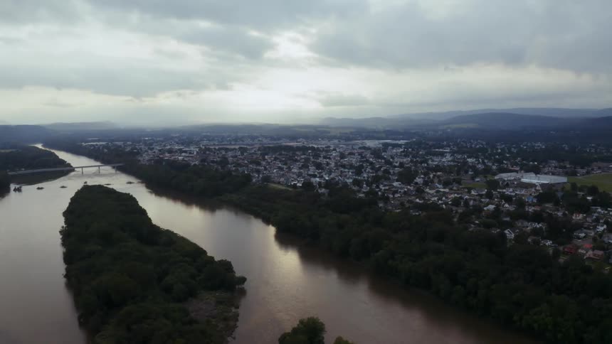 Aerial view of susquehanna river with bridge next to city on a cloudy day
