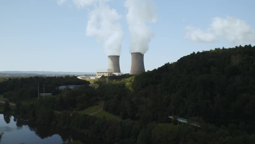 Smoke pours out of two tall silos at a nuclear power station