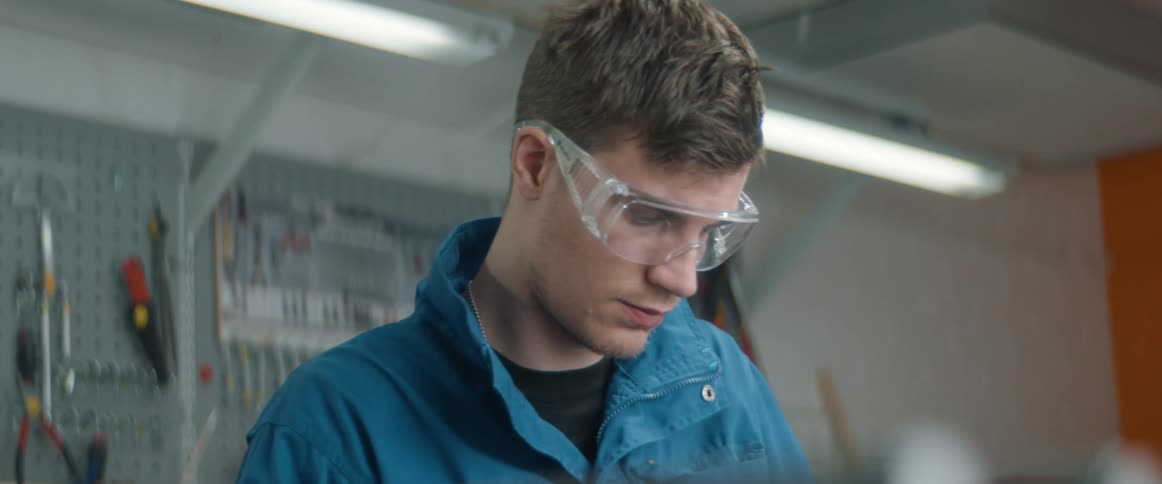 A man examines a plastic object in a lab