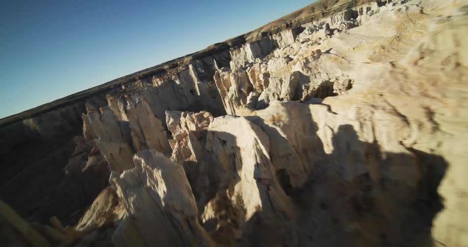 An aerial view of a large canyon with a person in the background walking past