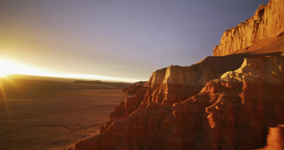 The sun shines brightly on rock formations in the desert