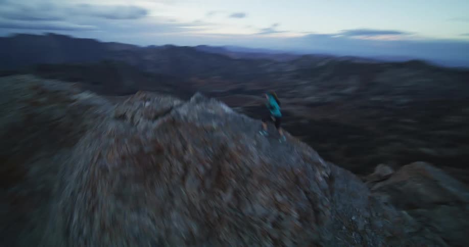 A woman hikes briskly up the stone mountain