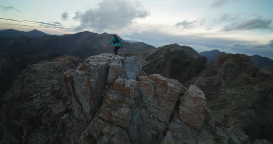 A person is rock climbing on a mountain at dusk