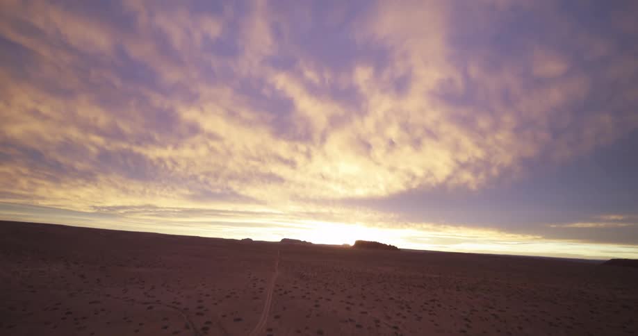 A narrow paved road runs through a desert