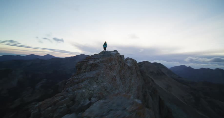 A woman runs across a cliff top