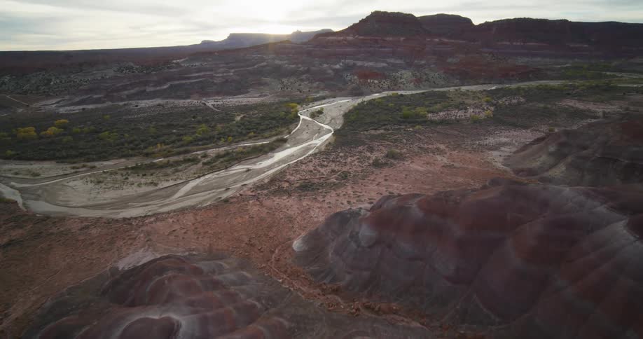 A dirt road runs through a vast canyon with rough terrain