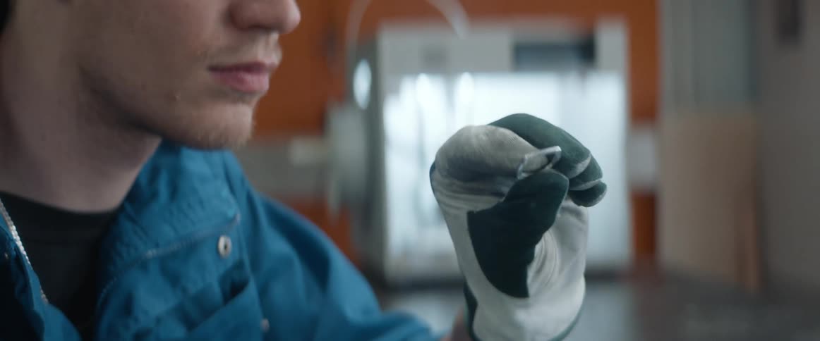 A man examines a metal ring and begins to use a metal file on it