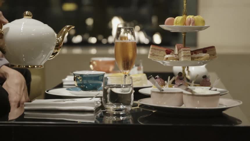 Tea is being poured by a fireplace