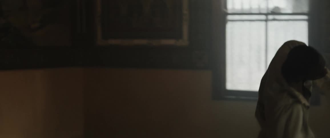 A man is dancing in a room near a window