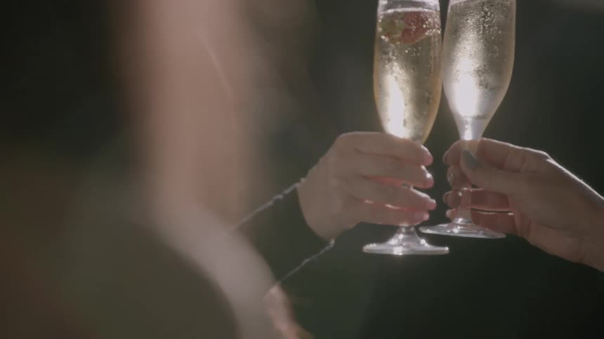 Two glasses are lifted in a toast