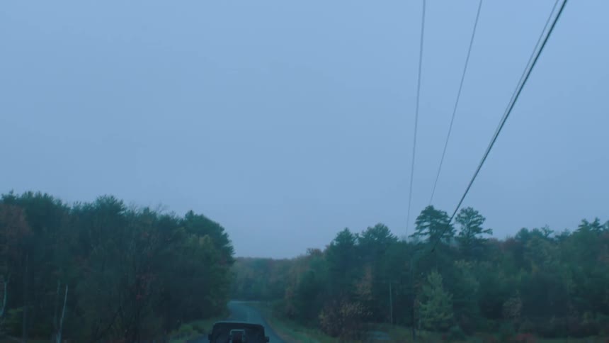 Electric lines overhead as a vehicle drives in a rural area
