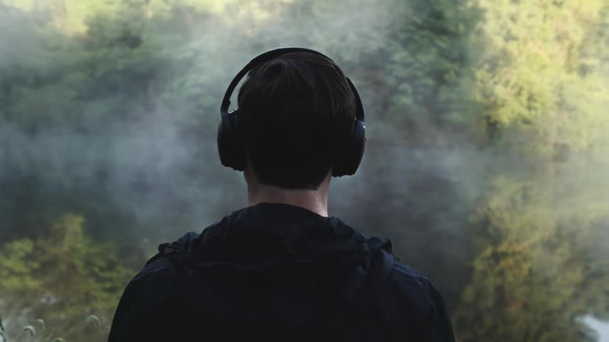 A man outdoors wearing headphones