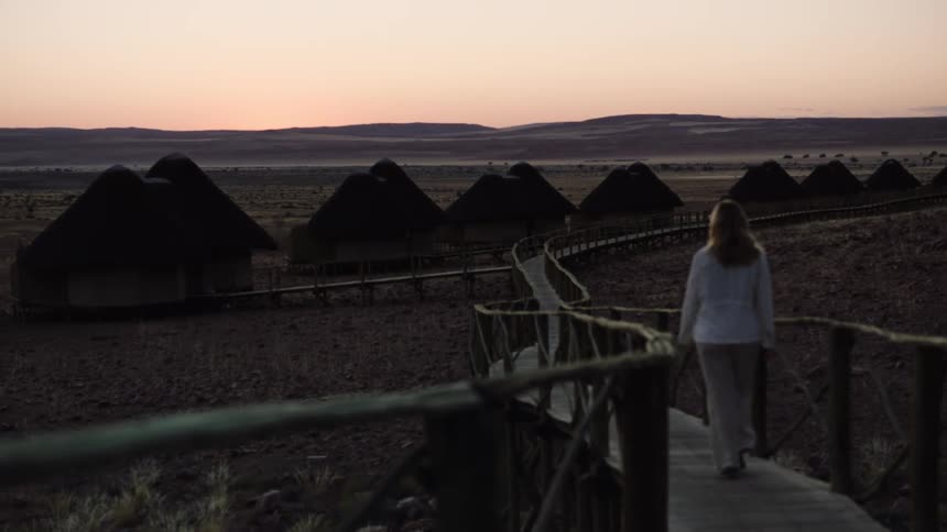 Young woman walking at desert resort during dusk
