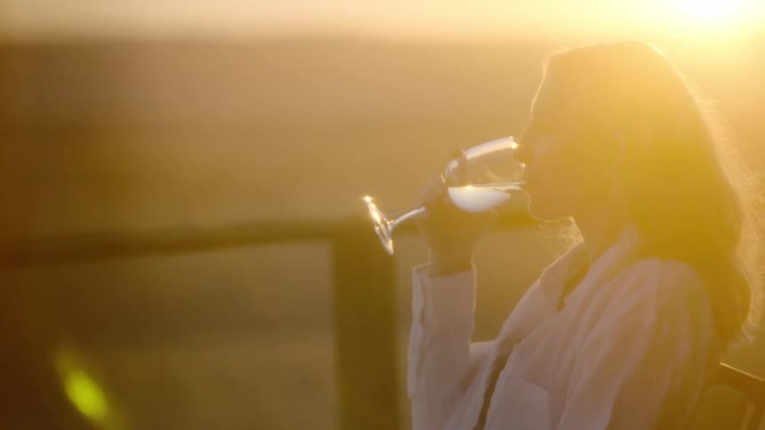 Young woman drinking wine at desert resort