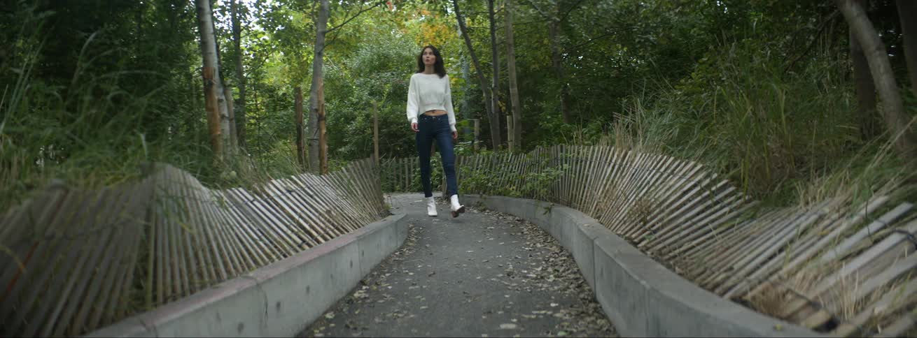 Young girl leisurely walking on a path in the park at daytime