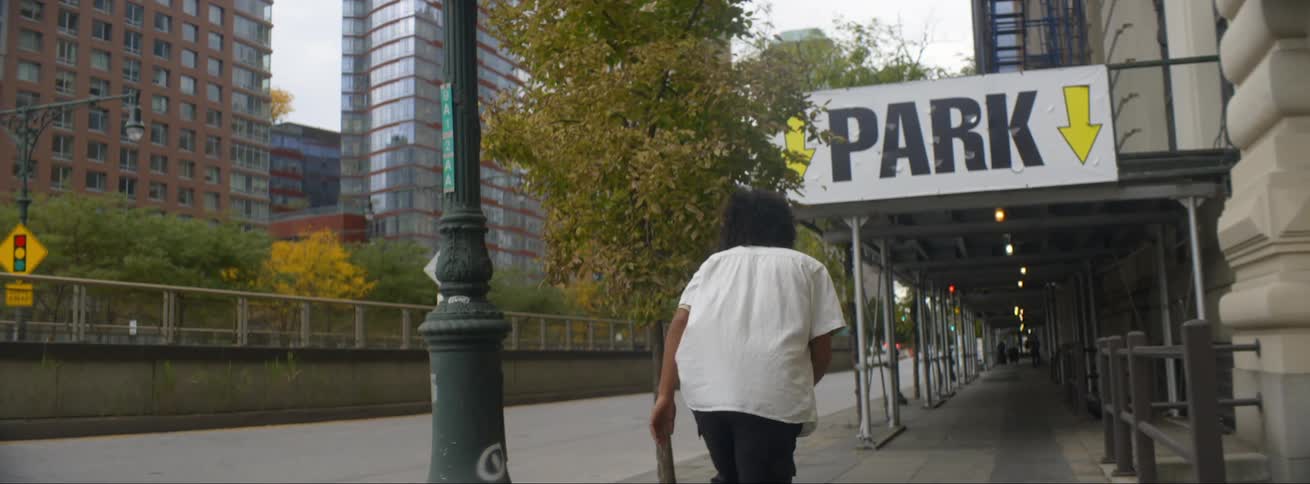 A man is skateboarding through a downtown city