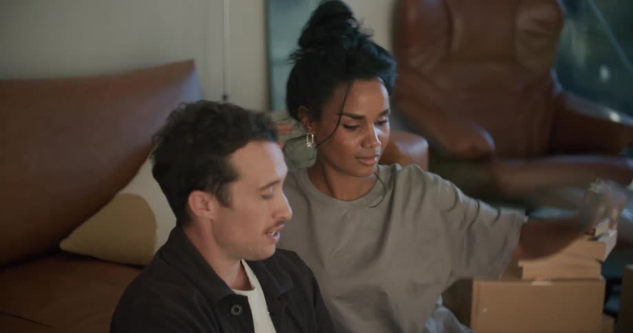 A man and woman look at a tablet and talk
