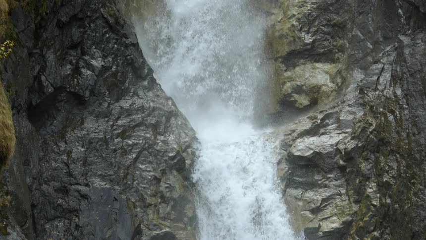 A powerful waterfall streaming down the rocky face of a mountain