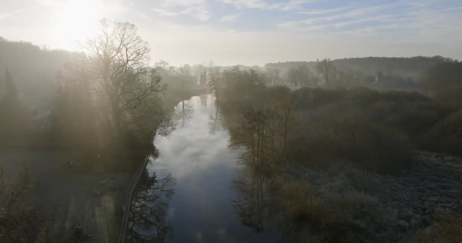 The sun is rising on the river