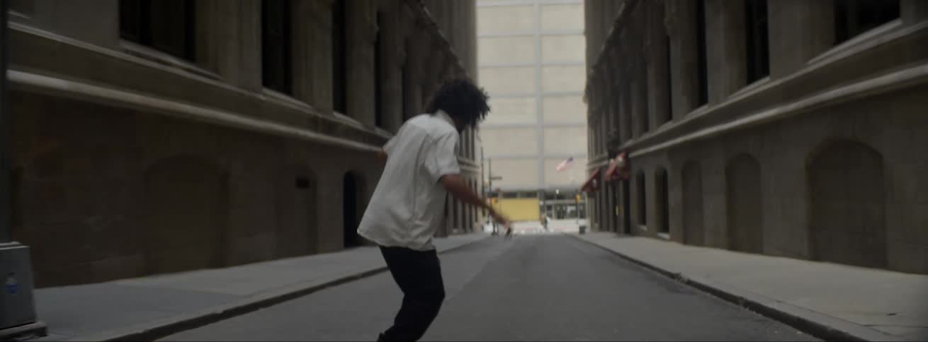 A man is riding his skateboard down the road