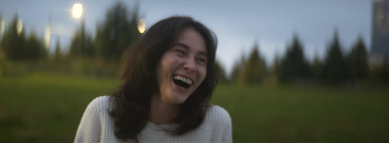 A woman is laughing on the field