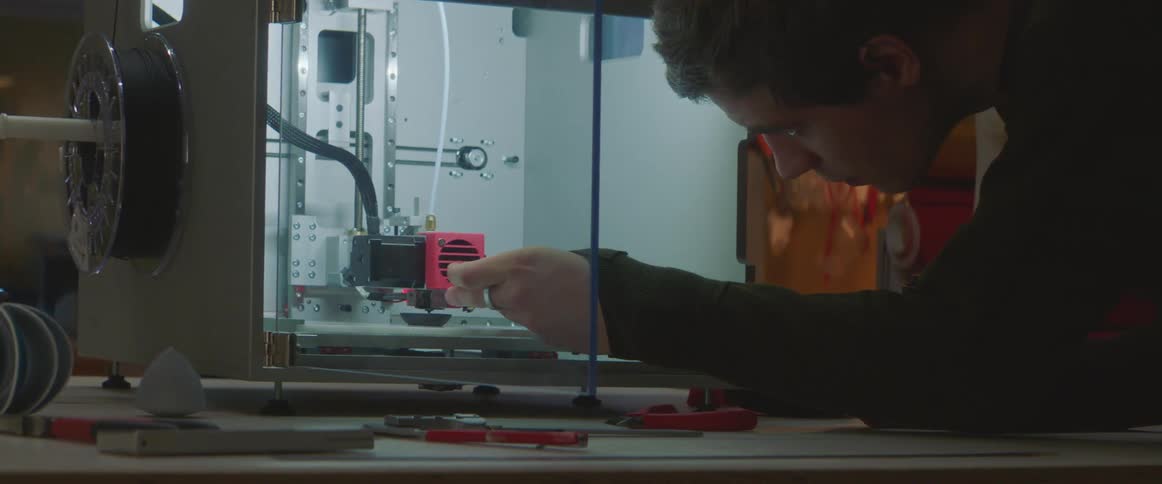 A man loading things into a 3d printer