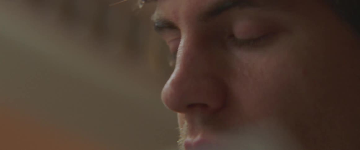 A man is holding a pen and writing on a tablet close to his face