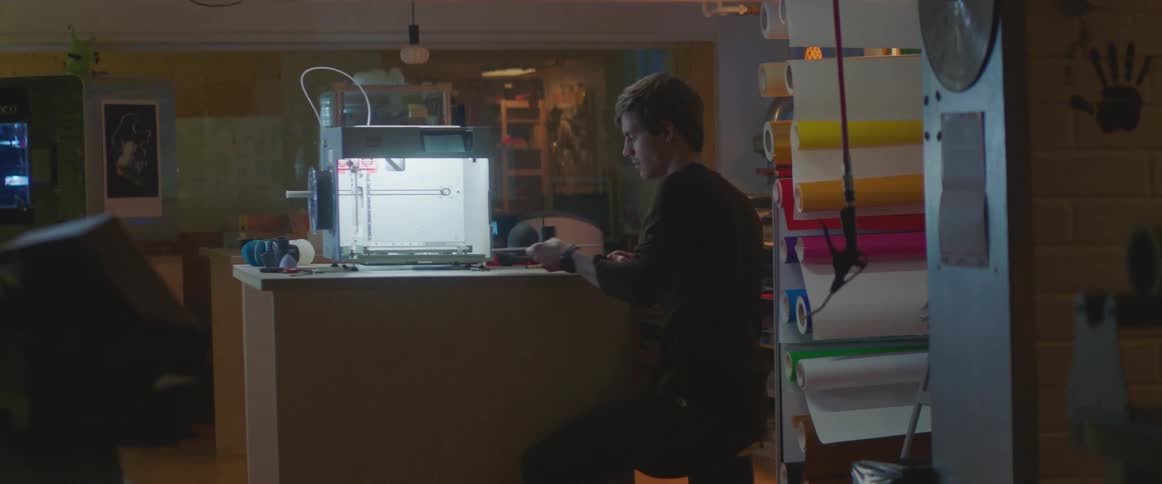 A man in a lab takes a small structure out of a 3d printer