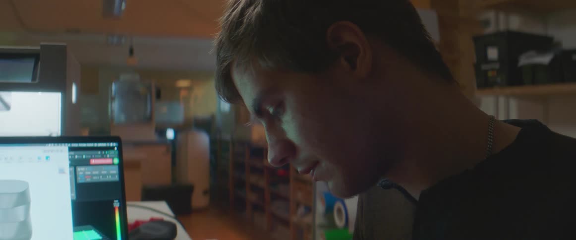 A man in a room in front of a computer screen