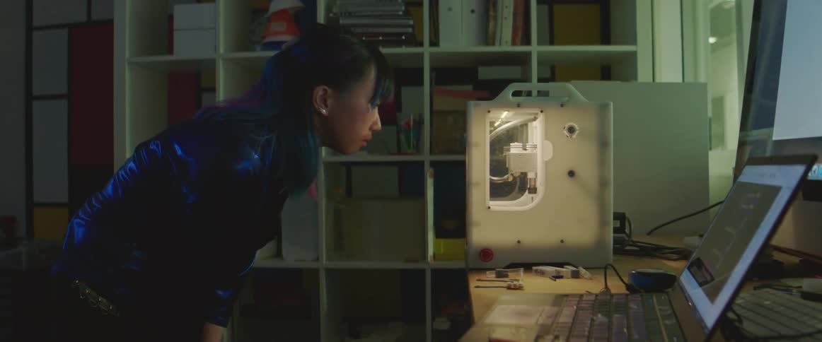 A woman looks over at her 3d printer
