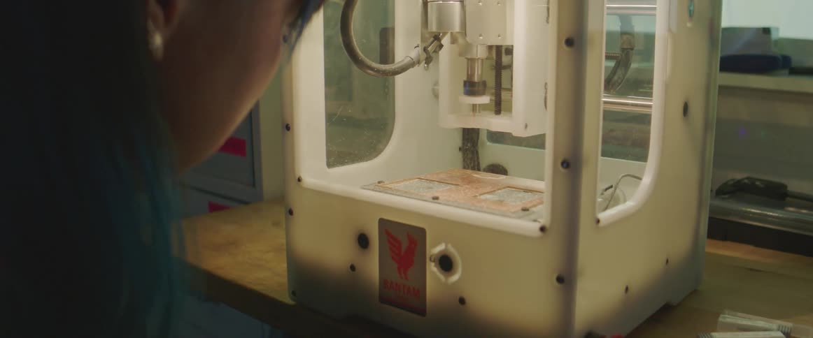 Woman watches machine arm move around in case