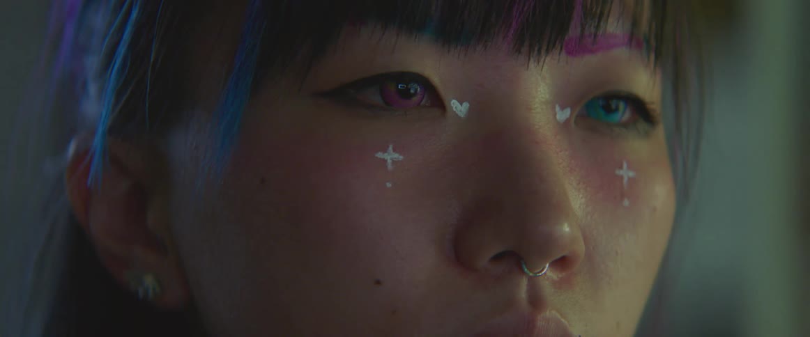 A close up of a asian teenagers face with stars and crosses painted on her