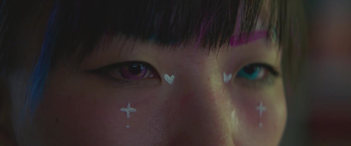 Woman wearing face paint has two different colored contact lenses