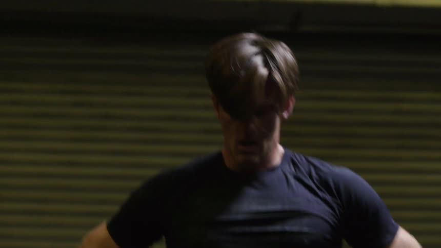 A man is walking with his hands on his hips breathing heavy