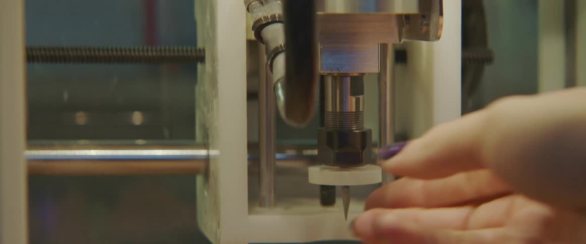 Someone is working on a 3d printer with a wrench