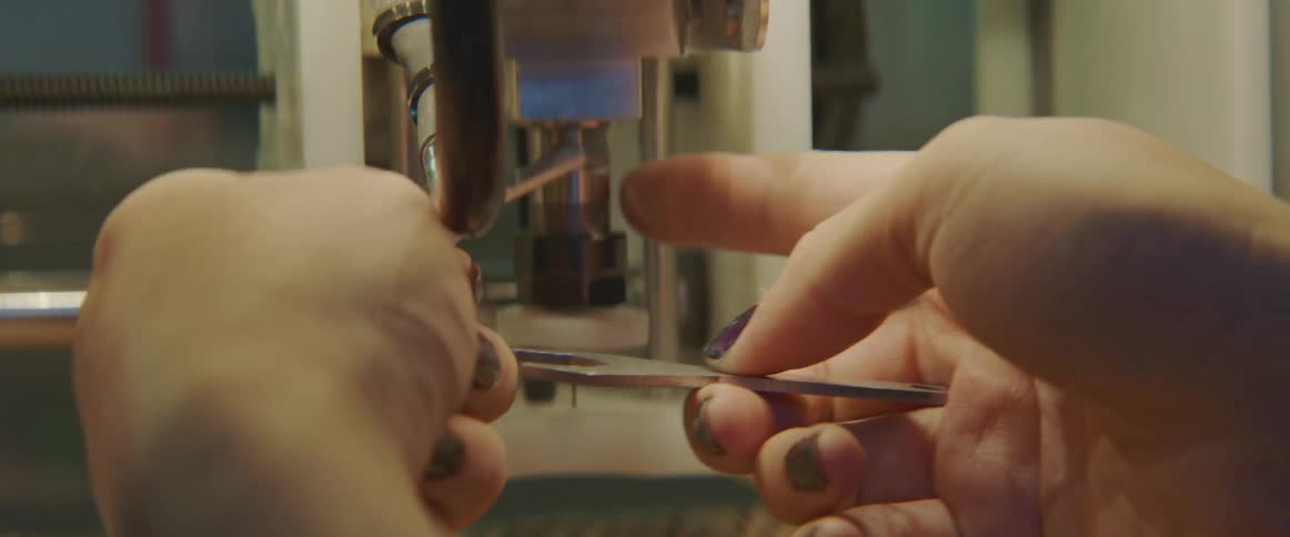 A person uses a tool to fix the 3d machine