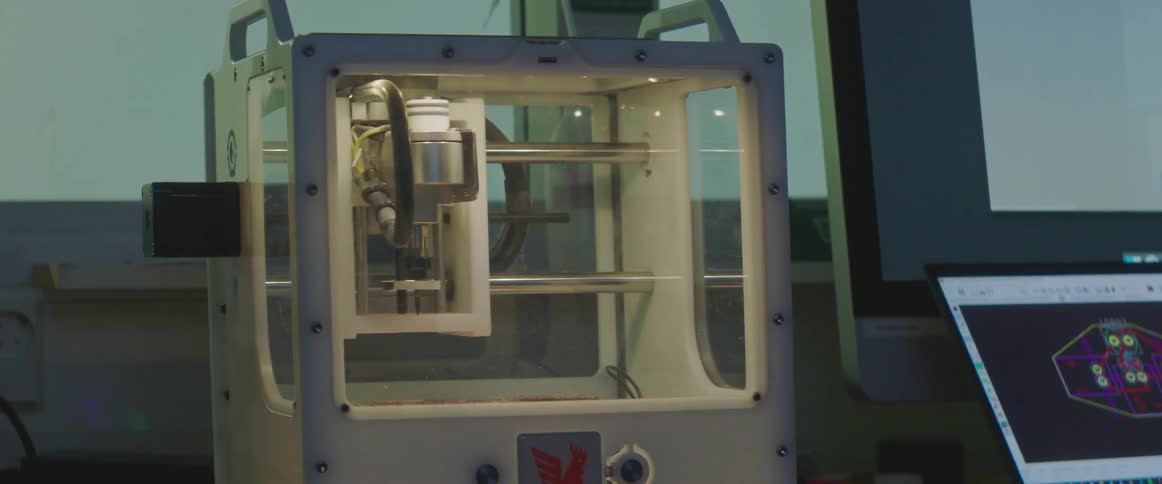 A laptop controls the movements of a milling machine