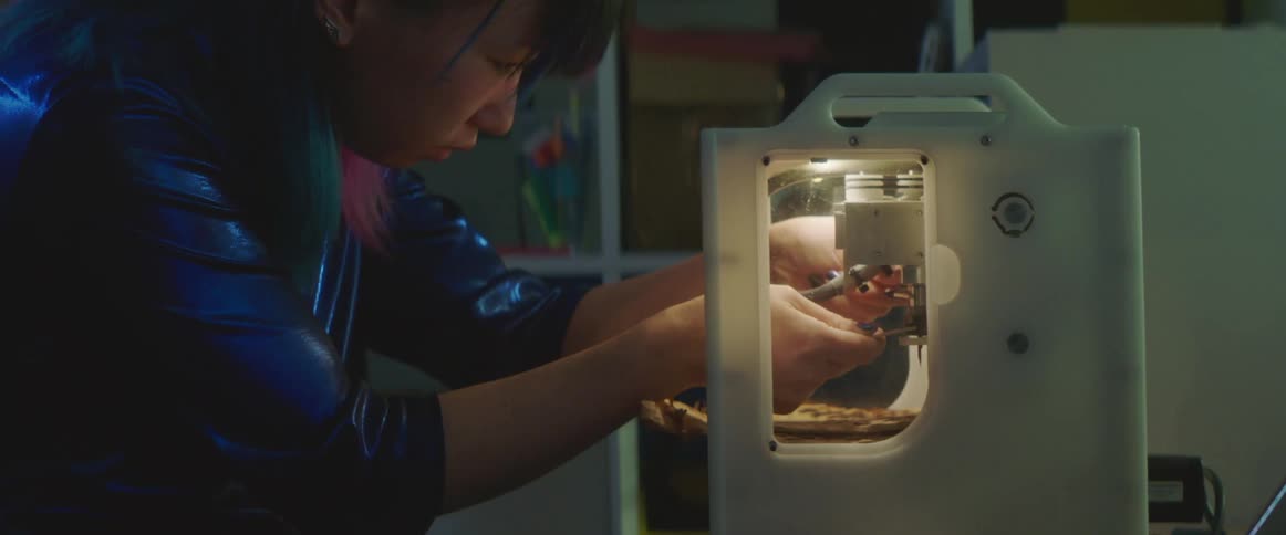 A teenager adjusts a needle on a machine