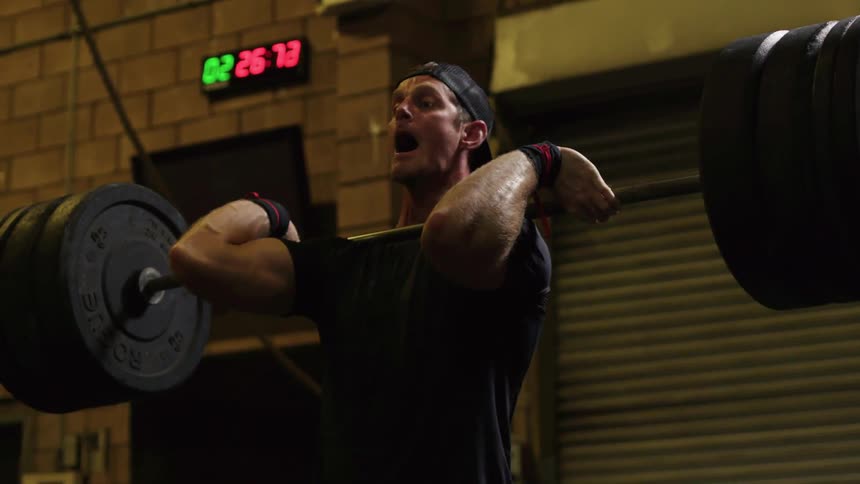 A man dead lifts heavy weights before dropping it