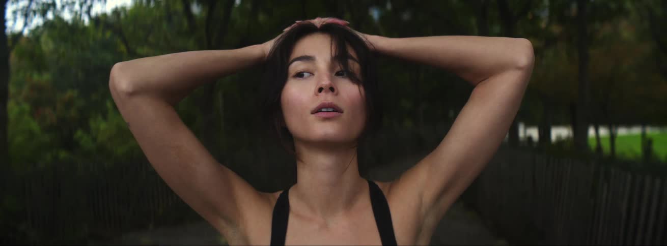 Woman in sports bra and leggings jogs in public park