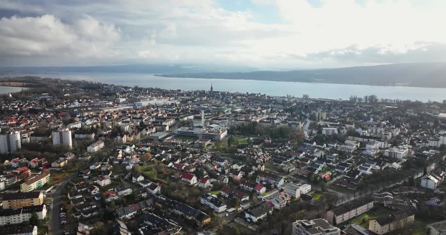 Aerial view of city buildings next to river under clouds