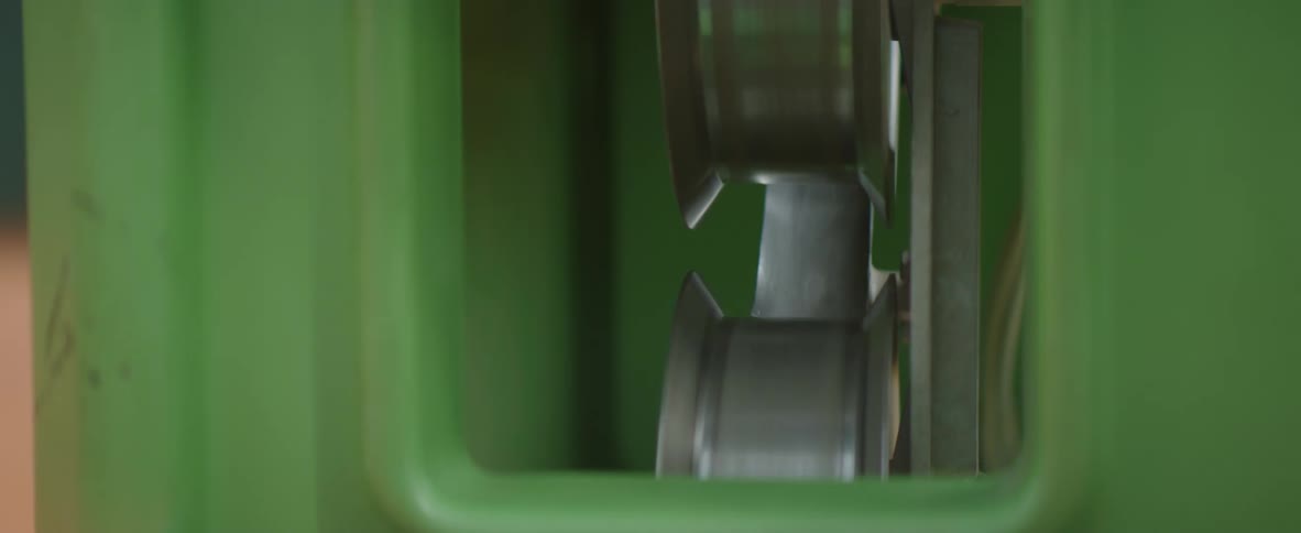 Green tennis ball shootingo out of a machine in the middle of a tennis court at daytime