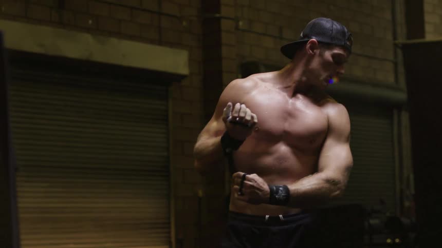 A man wraps his wrists in a gym