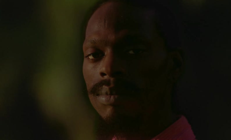 Man with mustache and goatee stares as he poses
