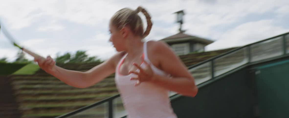 A tennis player volleys balls on the court