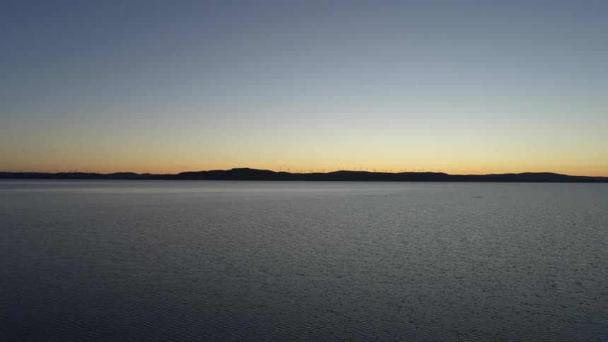 Mountains across the water on the horizon as the sun has set