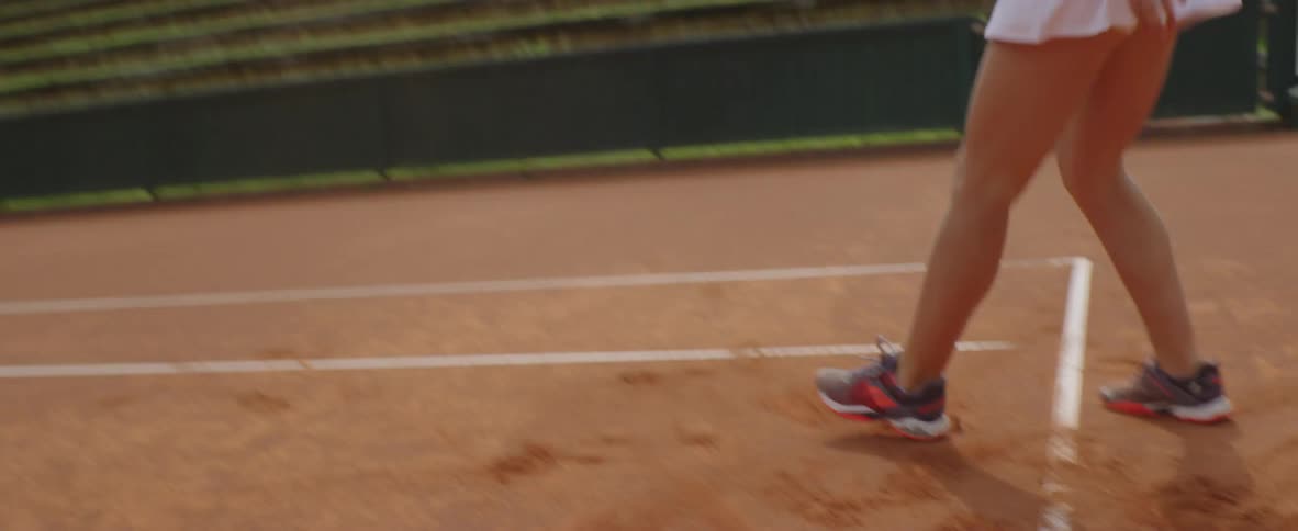 A tennis player runs along the court
