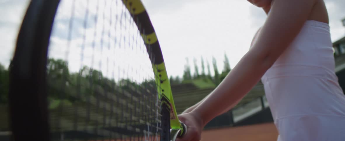 Female tennis player moves to catch ball with her racket